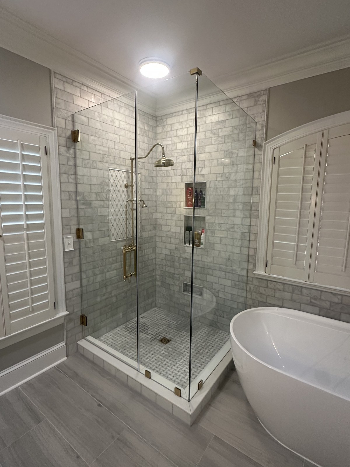Frameless corner shower enclosure with brass hardware