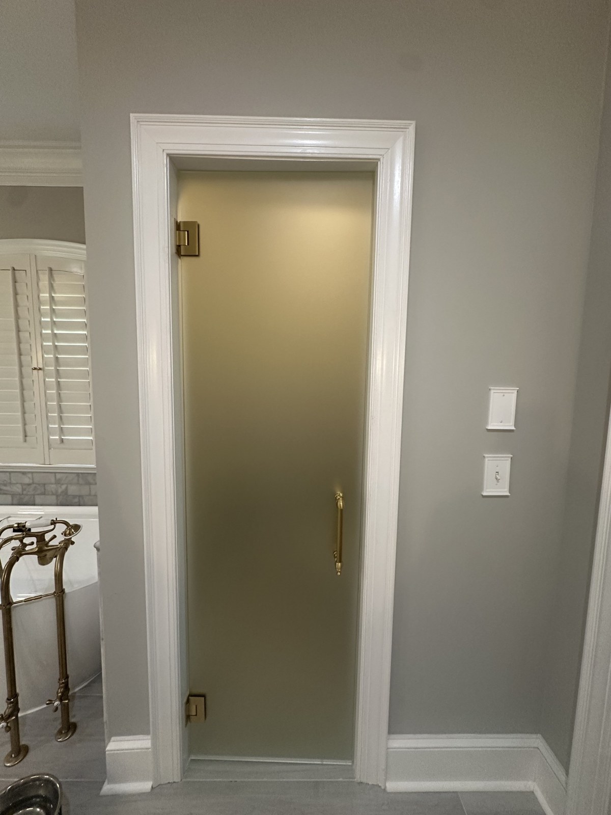 Frosted glass bathroom door with matching brass hardware